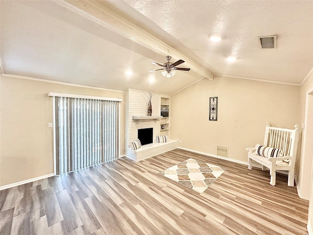 3317 Hummingbird, Denton, TX 76209 - unfurnished living room featuring ceiling fan, wood finished floors, a textured ceiling, a brick fireplace, and baseboards