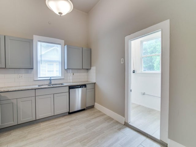 500 N Virginia St, Terrell, TX 75160 - kitchen featuring dishwasher, gray cabinetry, a sink, decorative backsplash, and light stone counters