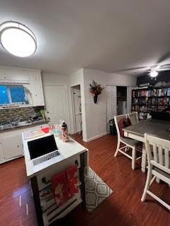 214 Pecos St, Garland, TX 75041 - kitchen with white cabinets and wood finished floors