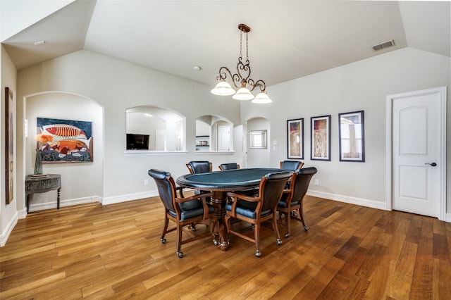 dining room featuring lofted ceiling, wood finished floors, and baseboards