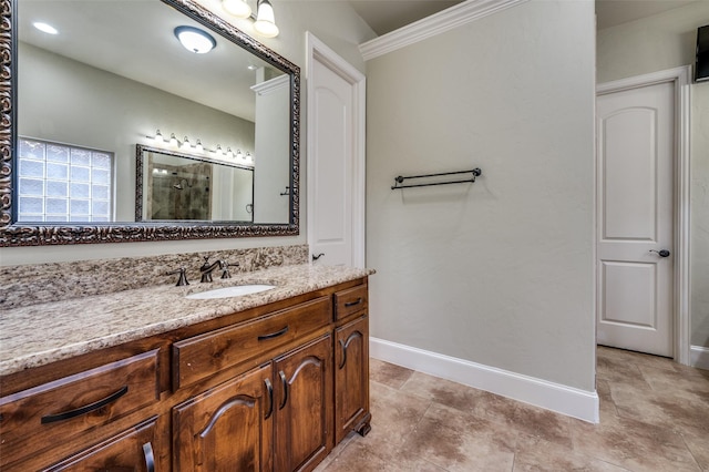 full bath with walk in shower, baseboards, vanity, and ornamental molding