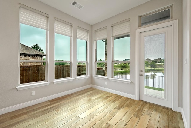 1116 Lake Hills Trl, Roanoke, TX 76262 - unfurnished sunroom featuring wood finished floors, a water view, and baseboards