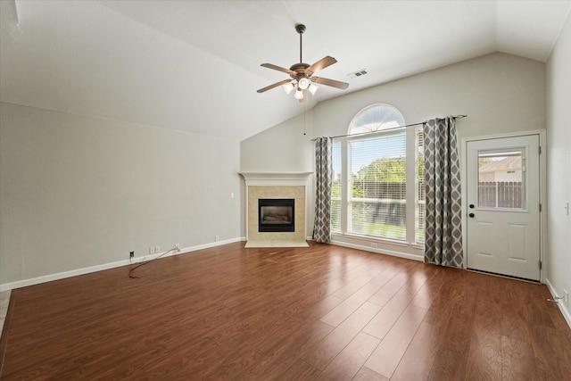 unfurnished living room featuring lofted ceiling, a ceiling fan, wood finished floors, a fireplace, and baseboards