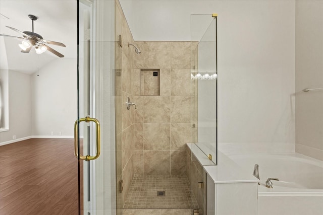 full bath featuring a ceiling fan, a stall shower, wood finished floors, a bath, and vaulted ceiling