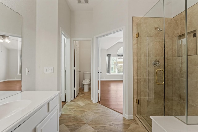 full bathroom featuring a shower stall, vanity, vaulted ceiling, toilet, and ceiling fan