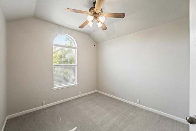 spare room with lofted ceiling, a ceiling fan, baseboards, and carpet floors