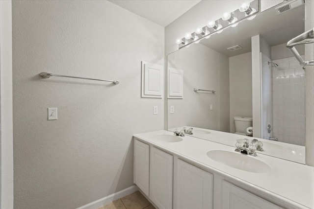 full bath with toilet, baseboards, double vanity, tile patterned floors, and a shower