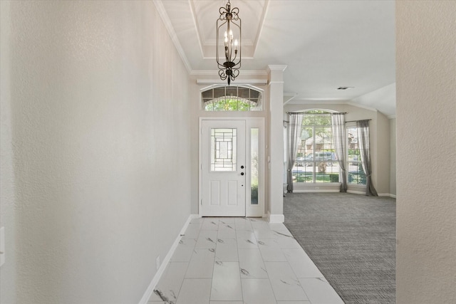 foyer with baseboards, a chandelier, a textured wall, crown molding, and marble finish flooring