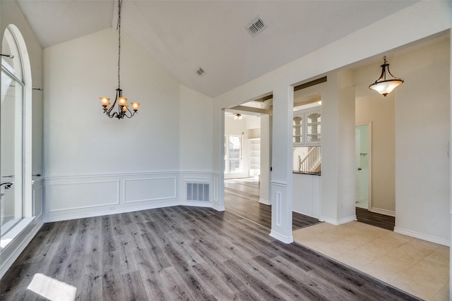 4804 Nocona Dr, Plano, TX 75024 - unfurnished dining area with high vaulted ceiling, a chandelier, wood finished floors, and wainscoting