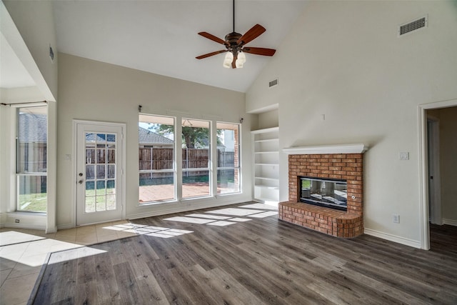 4804 Nocona Dr, Plano, TX 75024 - unfurnished living room featuring high vaulted ceiling, wood finished floors, a ceiling fan, built in shelves, and baseboards