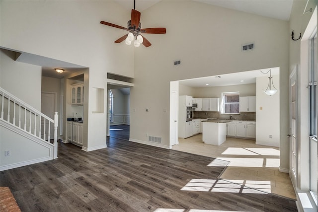 4804 Nocona Dr, Plano, TX 75024 - unfurnished living room with light wood-style flooring, a ceiling fan, high vaulted ceiling, and baseboards