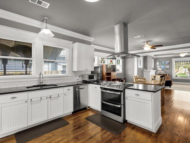 1942 Fairmount Ave, Fort Worth, TX 76110 - kitchen featuring appliances with stainless steel finishes, a sink, island exhaust hood, a peninsula, and dark countertops