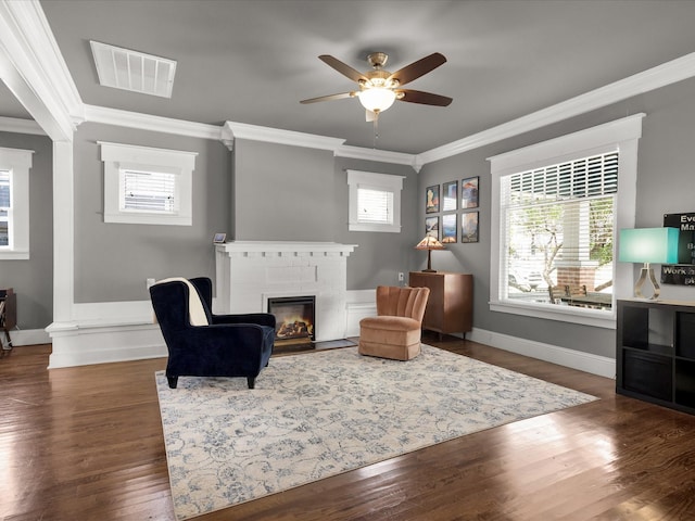 1942 Fairmount Ave, Fort Worth, TX 76110 - living room with crown molding, a brick fireplace, healthy amount of natural light, a ceiling fan, and wood finished floors