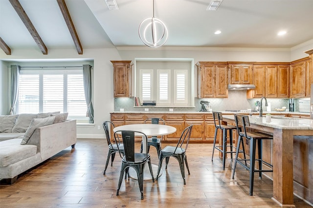 4701 Trevor Trl, Grapevine, TX 76051 - kitchen with under cabinet range hood, healthy amount of natural light, a kitchen breakfast bar, decorative backsplash, and recessed lighting
