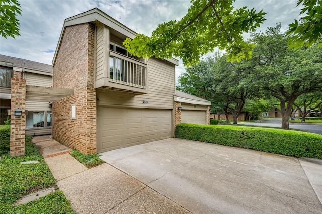 6780 E NW Hwy, Dallas, TX 75231 - view of front of home with a balcony, brick siding, a garage, and driveway