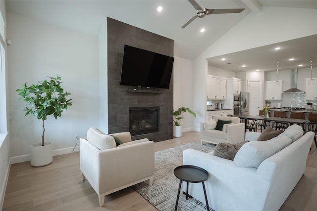 living area with ceiling fan, light wood finished floors, beam ceiling, recessed lighting, and baseboards