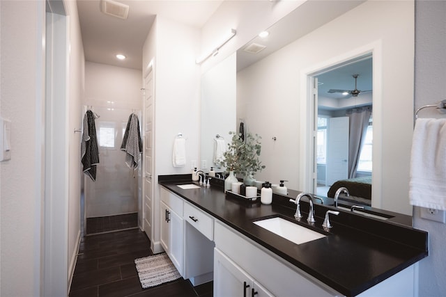 full bathroom with ensuite bathroom, tiled shower, double vanity, ceiling fan, and recessed lighting