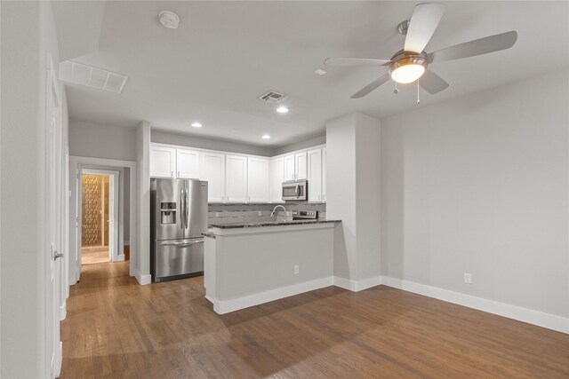 1317 Palm Canyon Dr, Dallas, TX 75204 - kitchen featuring stainless steel appliances, dark countertops, white cabinetry, tasteful backsplash, and dark wood-style flooring
