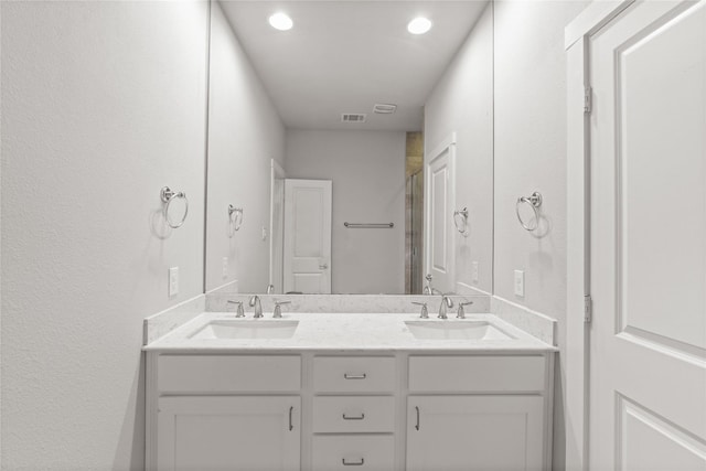 1317 Palm Canyon Dr, Dallas, TX 75204 - bathroom featuring double vanity, a textured wall, an enclosed shower, and recessed lighting