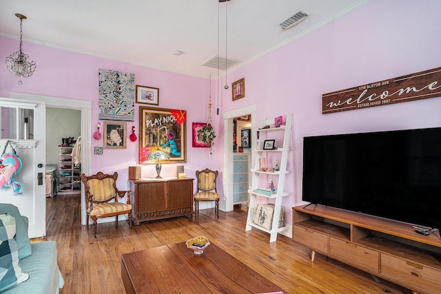 living area with crown molding and wood finished floors
