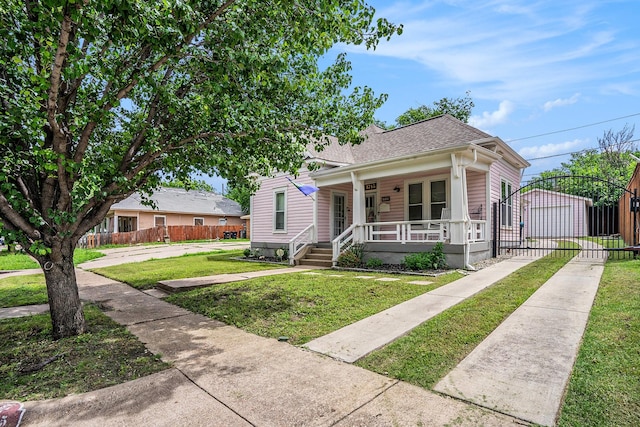 view of front of home featuring covered porch, an outdoor structure, and a shingled roof