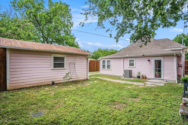 back of property featuring central AC unit and metal roof