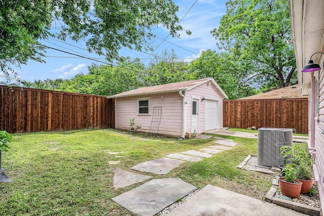 view of yard with central AC unit, an outbuilding, and a garage