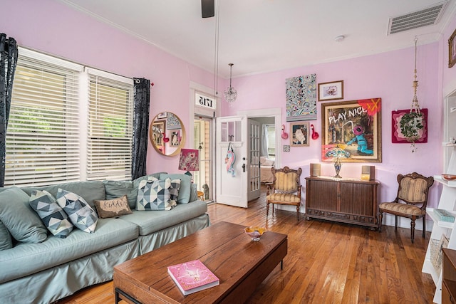 living area featuring crown molding, hardwood / wood-style flooring, and a ceiling fan