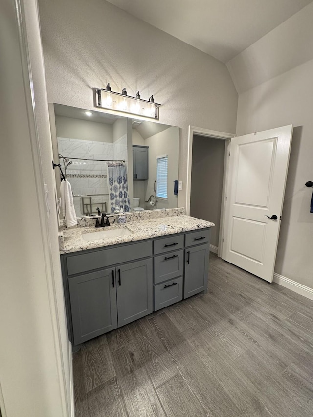 252 Harvard Ln, Springtown, TX 76082 - full bath featuring wood finished floors, a tile shower, vaulted ceiling, vanity, and baseboards