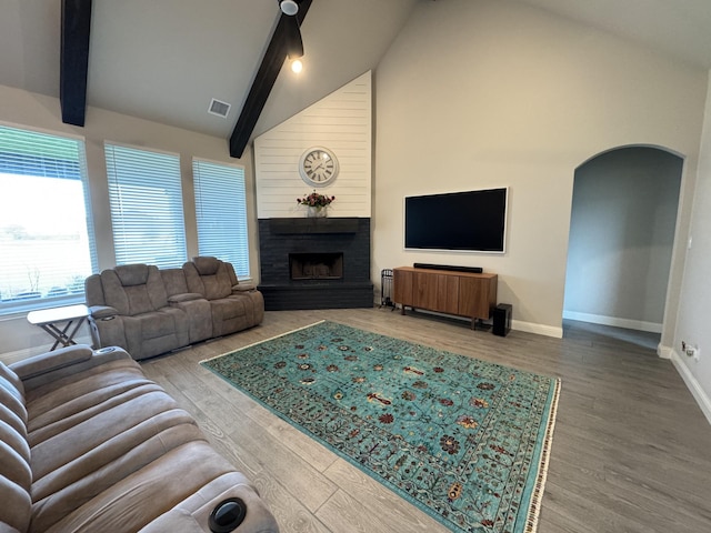 252 Harvard Ln, Springtown, TX 76082 - living room with arched walkways, baseboards, a large fireplace, wood finished floors, and beamed ceiling