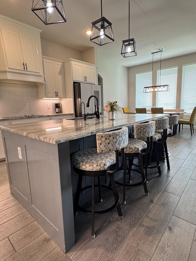 252 Harvard Ln, Springtown, TX 76082 - kitchen featuring light wood-style flooring, a spacious island, tasteful backsplash, white cabinetry, and recessed lighting