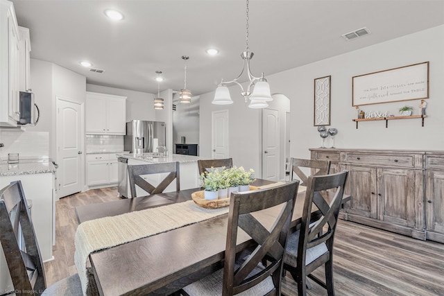 623 Comal Dr, Crandall, TX 75114 - dining area with light wood finished floors, recessed lighting, and arched walkways