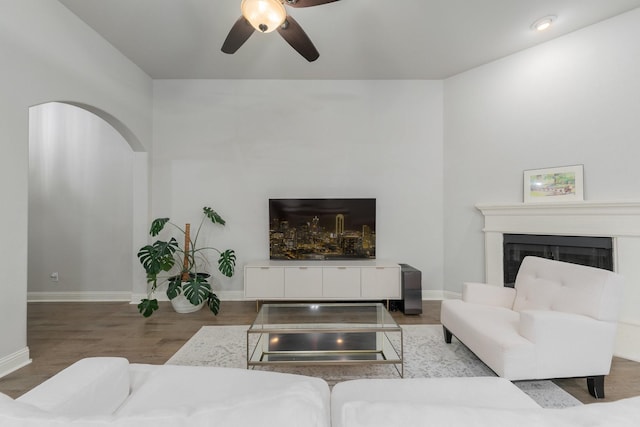 5604 Ridgeson Dr, Mckinney, TX 75071 - living area featuring a ceiling fan, a glass covered fireplace, baseboards, and wood finished floors