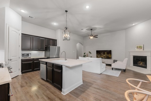 5604 Ridgeson Dr, Mckinney, TX 75071 - kitchen featuring a sink, appliances with stainless steel finishes, arched walkways, light countertops, and ceiling fan