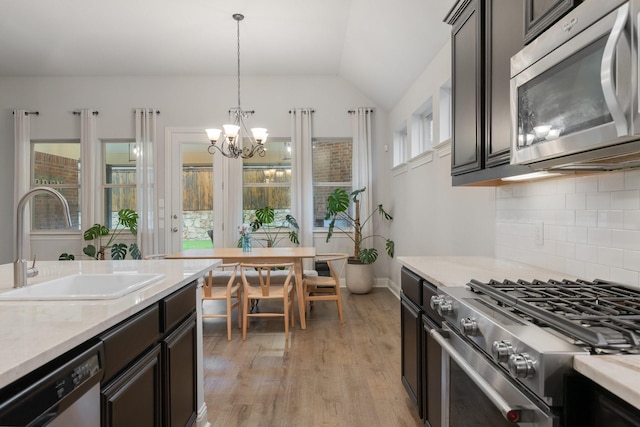 5604 Ridgeson Dr, Mckinney, TX 75071 - kitchen featuring stainless steel appliances, a sink, tasteful backsplash, lofted ceiling, and light countertops