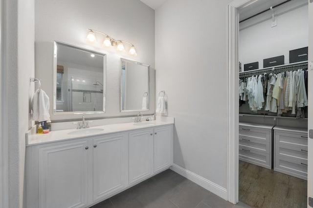 5604 Ridgeson Dr, Mckinney, TX 75071 - full bathroom with a stall shower, baseboards, a walk in closet, and double vanity