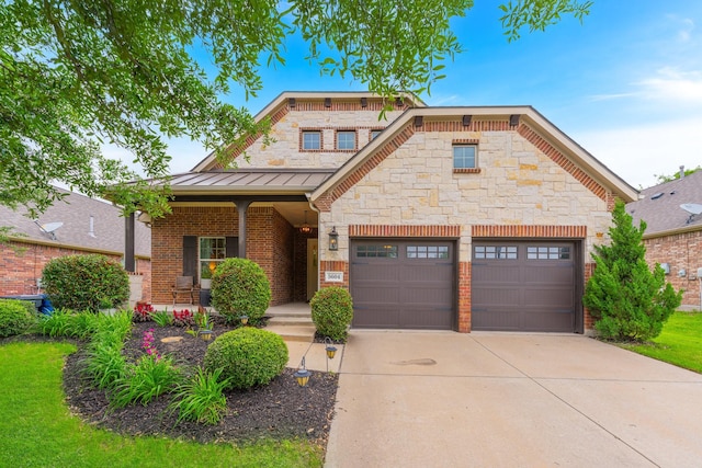 5604 Ridgeson Dr, Mckinney, TX 75071 - view of front facade featuring a standing seam roof, driveway, covered porch, an attached garage, and stone siding
