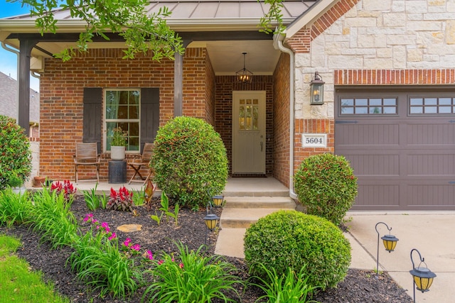5604 Ridgeson Dr, Mckinney, TX 75071 - doorway to property featuring covered porch, a garage, stone siding, brick siding, and a standing seam roof