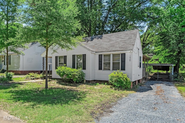 view of front facade featuring a shingled roof and a front yard