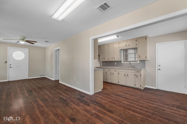 kitchen with light countertops, dark wood-type flooring, and baseboards