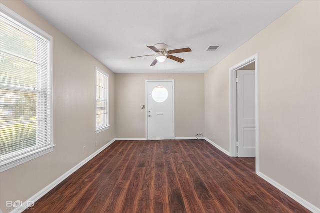 entrance foyer featuring ceiling fan, dark wood-style flooring, plenty of natural light, and baseboards