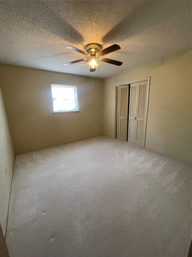 905 Seymore Cir, Denison, TX 75020 - unfurnished bedroom featuring a closet, carpet, ceiling fan, and a textured ceiling