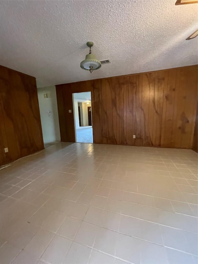905 Seymore Cir, Denison, TX 75020 - empty room with wooden walls and a textured ceiling