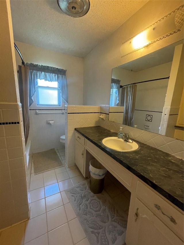 905 Seymore Cir, Denison, TX 75020 - full bath with tile walls, a textured ceiling, tile patterned flooring, toilet, and shower / bath combo with shower curtain