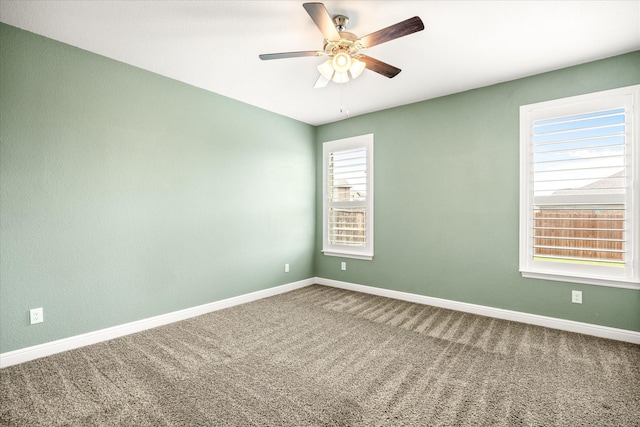carpeted empty room with ceiling fan and baseboards