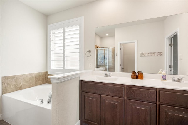 bathroom with a stall shower, a bath, and double vanity