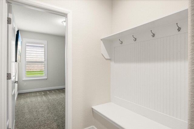 mudroom with carpet floors and baseboards