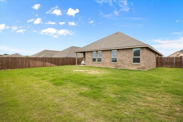 rear view of property featuring brick siding and roof with shingles