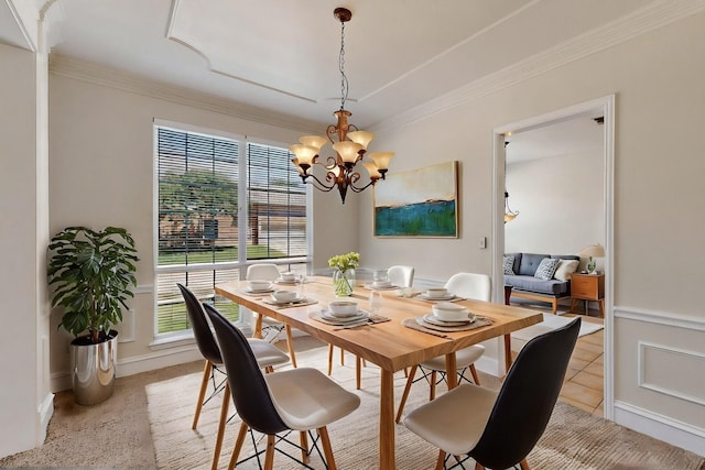 dining space with a chandelier, ornamental molding, and baseboards