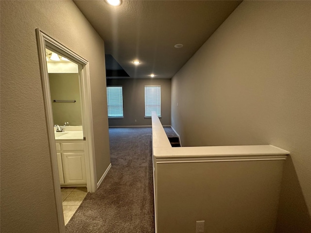 corridor with carpet flooring, recessed lighting, a textured wall, and baseboards